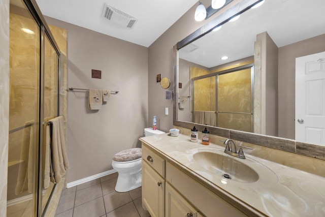 bathroom featuring tile patterned flooring, vanity, a shower with shower door, and toilet