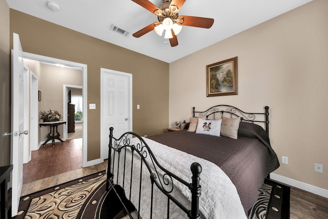 bedroom with dark hardwood / wood-style floors and ceiling fan