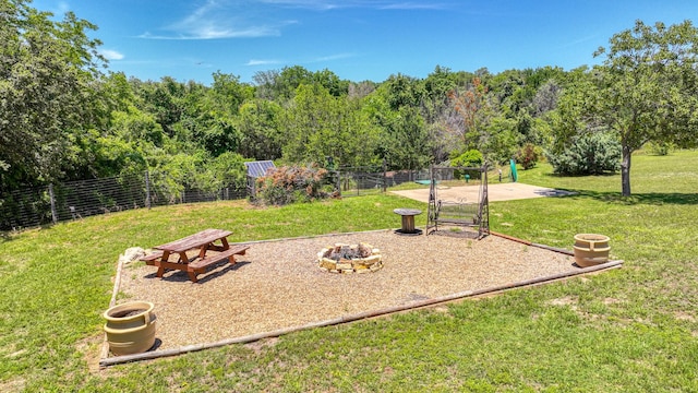 view of community with a fire pit and a lawn