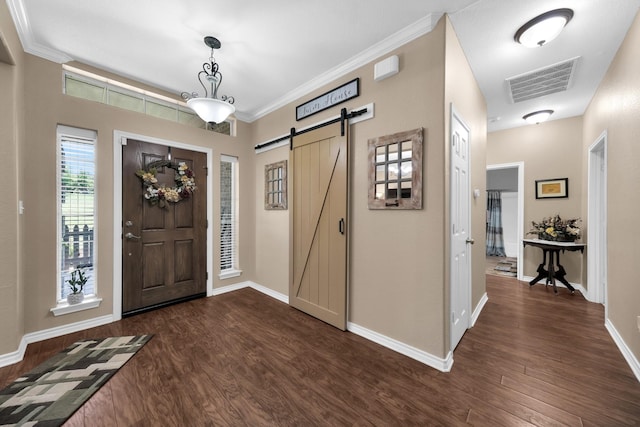 foyer featuring crown molding, a barn door, and dark hardwood / wood-style flooring