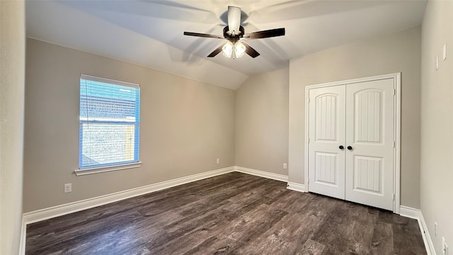 unfurnished bedroom with dark wood-type flooring, ceiling fan, vaulted ceiling, and a closet