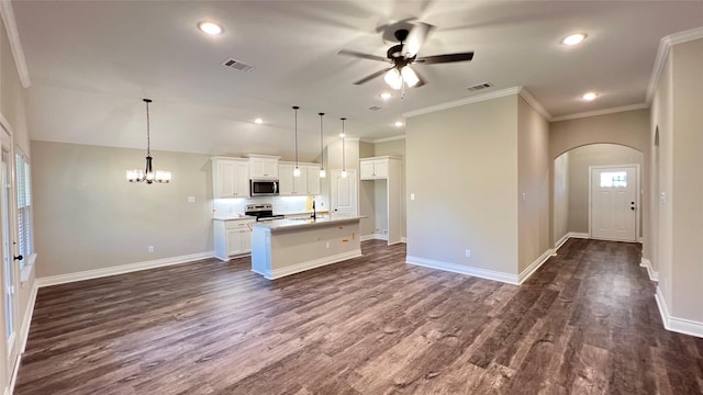 kitchen featuring white cabinetry, appliances with stainless steel finishes, decorative light fixtures, and an island with sink