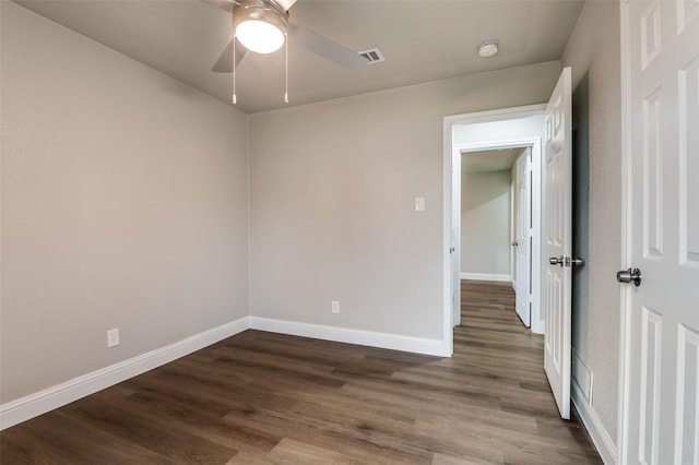 unfurnished room featuring dark wood-type flooring and ceiling fan