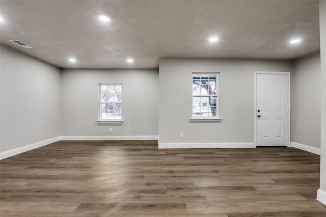 spare room with dark wood-type flooring and a textured ceiling