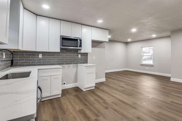 kitchen with sink, dark wood-type flooring, and white cabinets