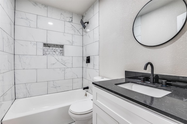 full bathroom with tiled shower / bath, vanity, and toilet