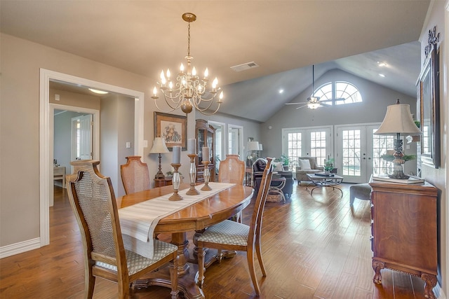 dining room featuring french doors, lofted ceiling, wood-type flooring, and ceiling fan with notable chandelier