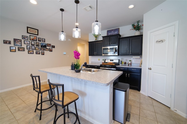 kitchen featuring sink, a kitchen breakfast bar, hanging light fixtures, a kitchen island with sink, and stainless steel appliances