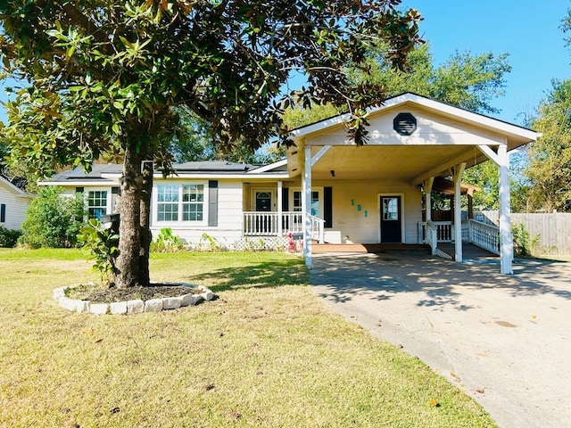 view of front of home featuring a front lawn, a carport, solar panels, and a porch