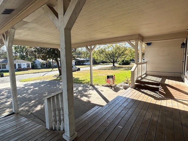 wooden deck featuring a lawn