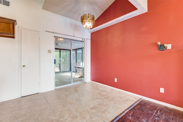 spare room with light tile patterned floors and a notable chandelier