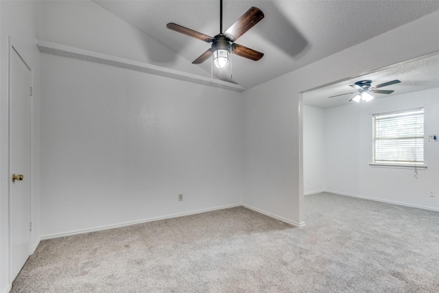 carpeted empty room with ceiling fan and a textured ceiling