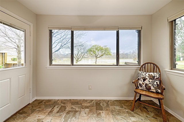 sitting room with stone finish floor and baseboards