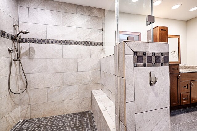 bathroom featuring recessed lighting, a walk in shower, and vanity