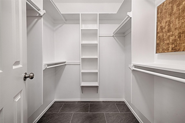 walk in closet featuring dark tile patterned floors