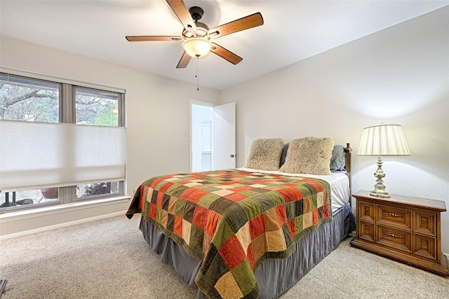 bedroom featuring a ceiling fan, light carpet, and baseboards