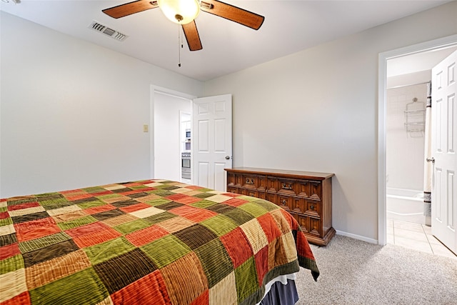 bedroom with light colored carpet, visible vents, ceiling fan, ensuite bath, and baseboards