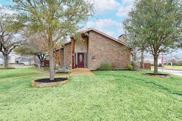 mid-century inspired home featuring a front lawn and brick siding