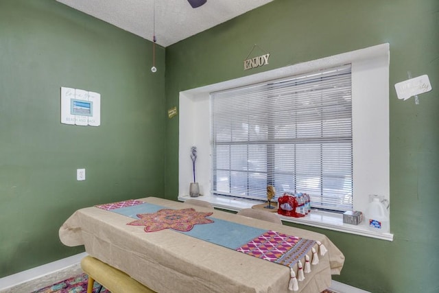 bedroom with ceiling fan and a textured ceiling