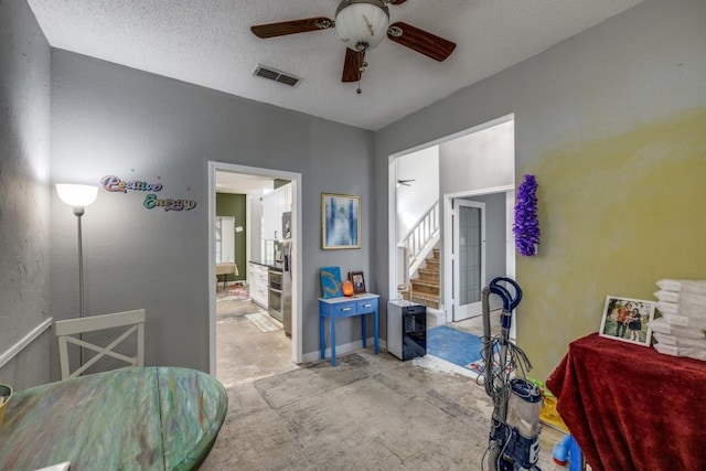 bedroom with ceiling fan and a textured ceiling