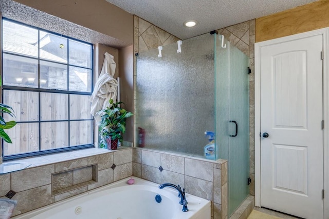 bathroom with shower with separate bathtub and a textured ceiling