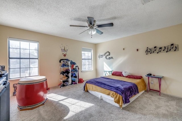 bedroom featuring ceiling fan, light carpet, and a textured ceiling