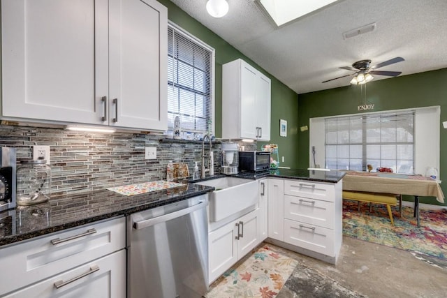 kitchen featuring tasteful backsplash, dark stone counters, dishwasher, and white cabinets