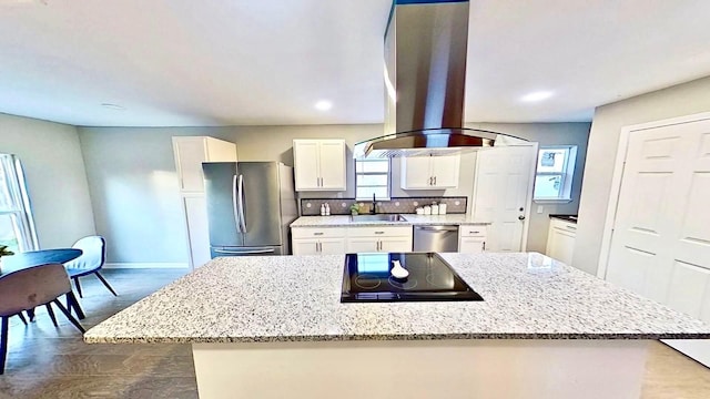 kitchen with sink, white cabinetry, plenty of natural light, stainless steel appliances, and island exhaust hood