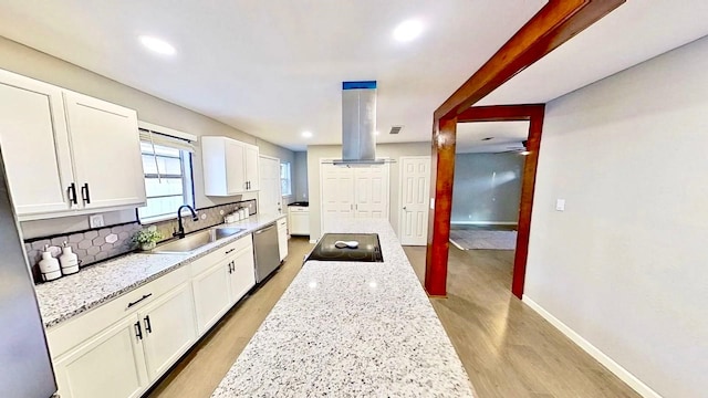 kitchen featuring sink, light stone counters, dishwasher, light hardwood / wood-style floors, and white cabinets