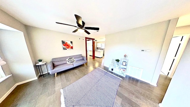 living room with ceiling fan and dark hardwood / wood-style flooring