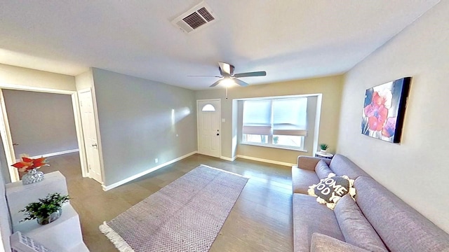 living room with dark hardwood / wood-style flooring and ceiling fan