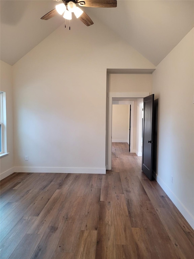 spare room featuring vaulted ceiling, dark wood-type flooring, and ceiling fan