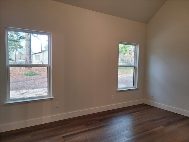 unfurnished room featuring dark hardwood / wood-style floors and vaulted ceiling