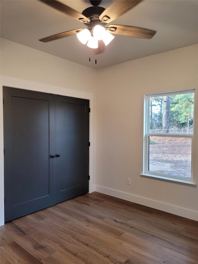 unfurnished bedroom with dark wood-type flooring and ceiling fan