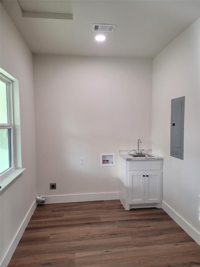 washroom featuring sink, dark hardwood / wood-style flooring, electric panel, hookup for a washing machine, and hookup for an electric dryer