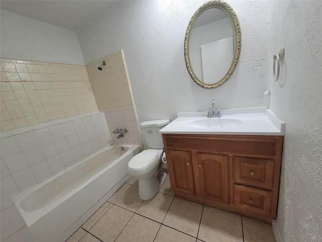 full bathroom featuring vanity, tiled shower / bath, tile patterned floors, and toilet