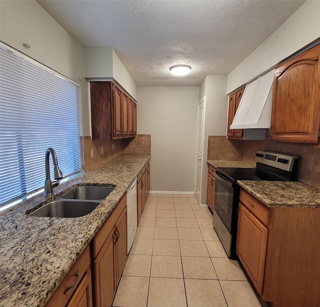 kitchen featuring dishwasher, sink, decorative backsplash, light tile patterned floors, and electric range