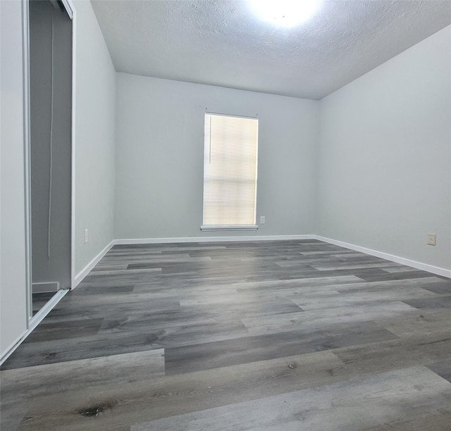 unfurnished room with dark hardwood / wood-style floors and a textured ceiling