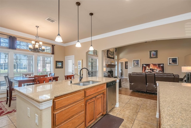 kitchen with sink, light tile patterned floors, hanging light fixtures, light stone countertops, and stainless steel dishwasher