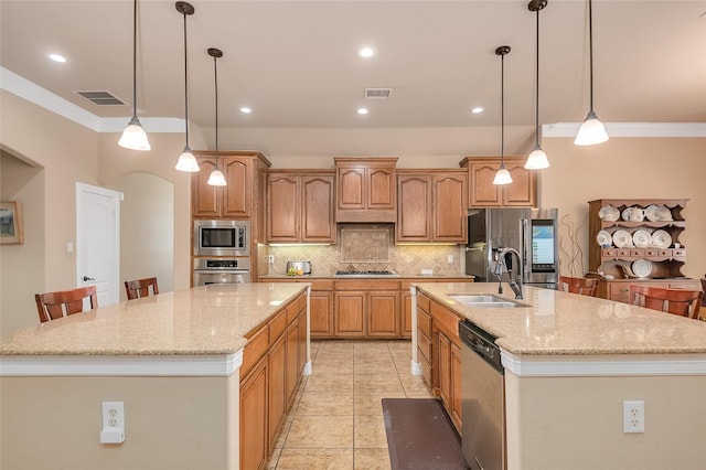 kitchen with a spacious island, a kitchen bar, sink, hanging light fixtures, and stainless steel appliances