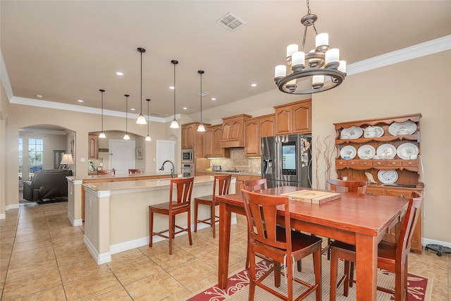 dining room with crown molding, sink, light tile patterned floors, and an inviting chandelier