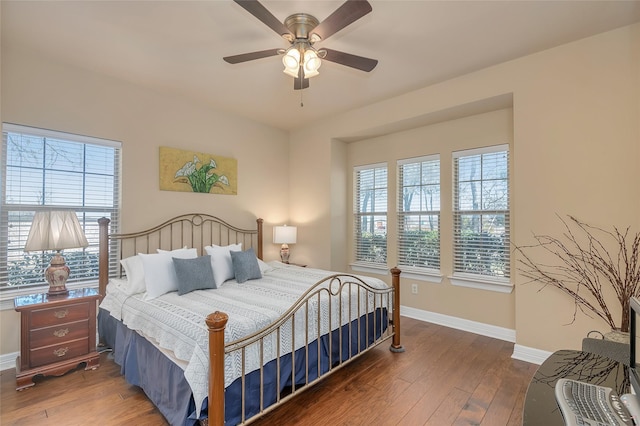 bedroom featuring dark wood-type flooring, ceiling fan, and multiple windows