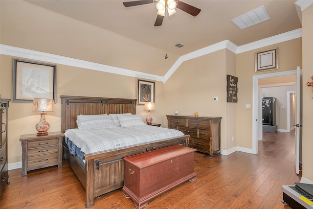 bedroom with hardwood / wood-style flooring, crown molding, lofted ceiling, and ceiling fan