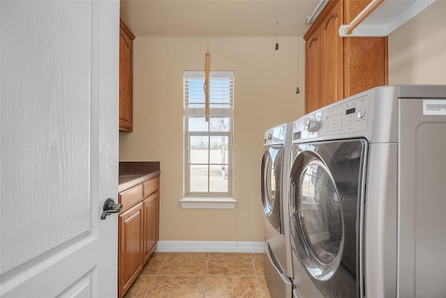 washroom featuring cabinets, washer and clothes dryer, and light tile patterned floors