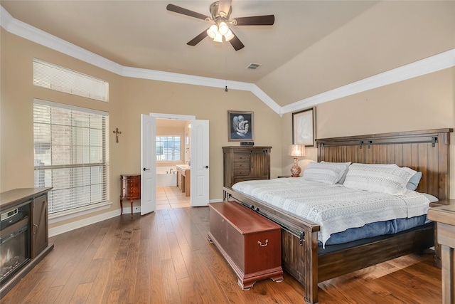 bedroom with crown molding, lofted ceiling, dark hardwood / wood-style floors, and connected bathroom