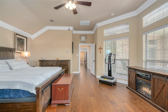 bedroom with ornamental molding, lofted ceiling, ceiling fan, and light wood-type flooring