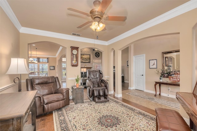 living room featuring hardwood / wood-style floors, crown molding, and ceiling fan