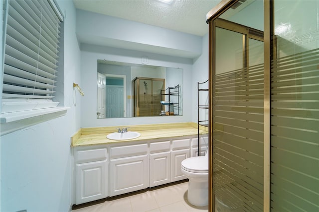 bathroom with a shower with door, tile patterned flooring, vanity, a textured ceiling, and toilet