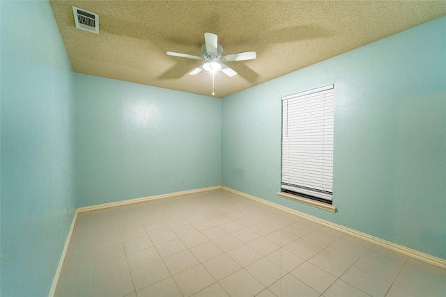 tiled empty room with a textured ceiling and ceiling fan