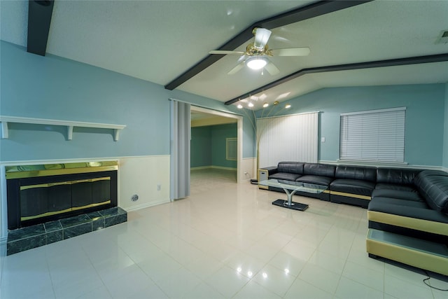 living room with vaulted ceiling with beams, a fireplace, ceiling fan, and light tile patterned flooring